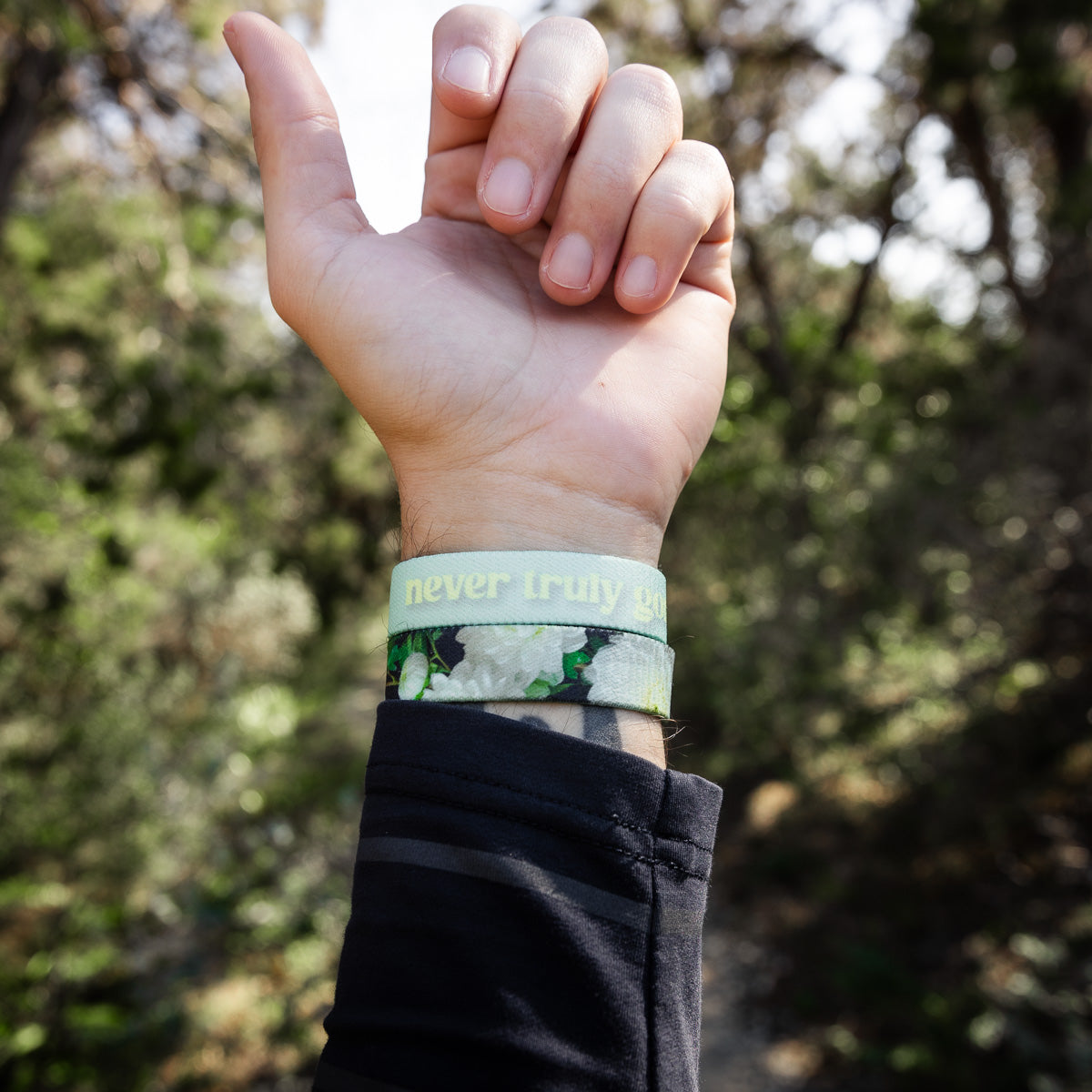 Closeup of someone's arm high through the trees, while wearing the wristband.