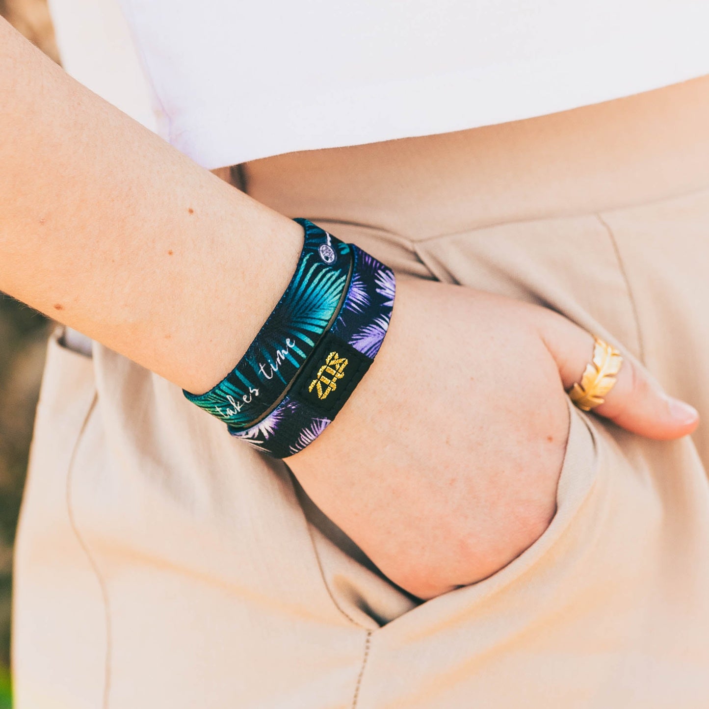 Closeup of someone with their hand in the pocket, wearing the band.