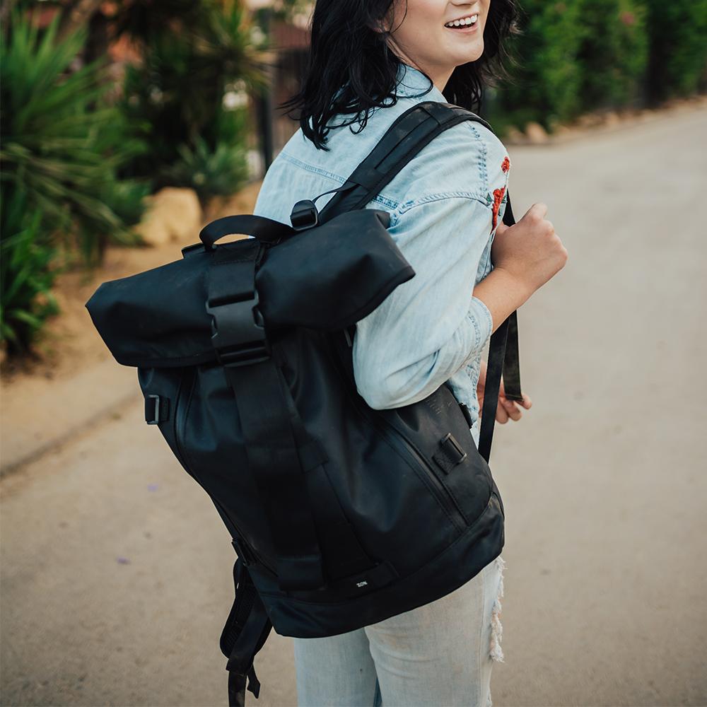 lifestyle photo of the Imperial v2 with a different the standard black tension and closure straps on a woman's shoulder while she smiles during a walk