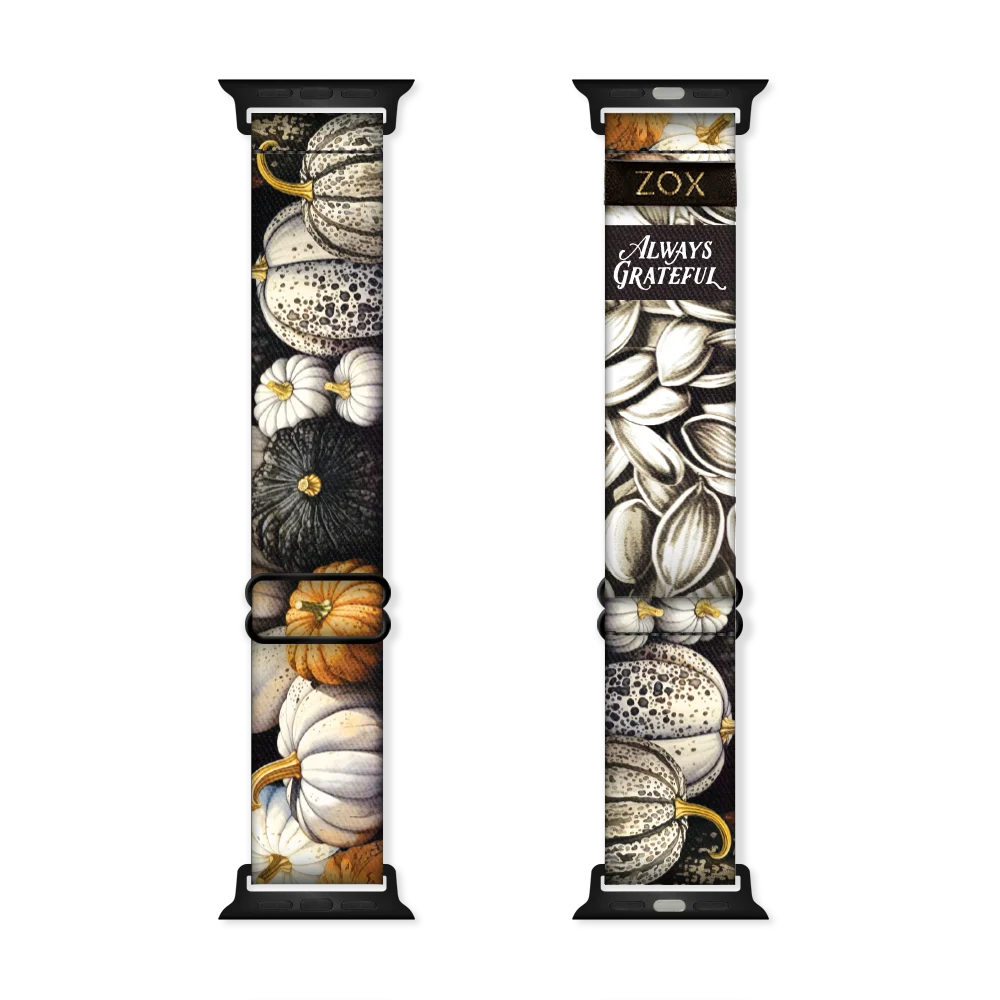 Apple Watch Band render of the Always Grateful Watch Band design, showing both the outside (left) and inside (right) of the band. The outer side on the left features detailed pumpkins in neutral tones of white, cream, orange, and black, creating a rustic, seasonal feel. The inside on the right is a mix of detailed pumpkins and flowers in neutral tones white, cream, orange, and black. Displayed on the band is the phrase "Always Grateful" in elegant white script. The ZOX logo is on a black tag sewn near top.