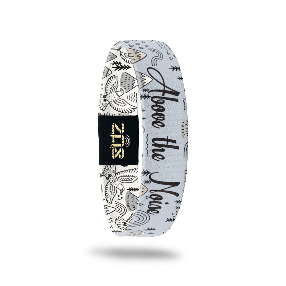 Inside of the Above the Noise bracelet, with the words Above the Noise across the mountain print