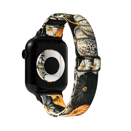 Product photo of the outside of the Always Grateful Watch Band. The design features large, intricately detailed flowers in shades of white, orange, and black with fine accents of yellow. The background is dark, allowing the vibrant floral patterns to stand out.