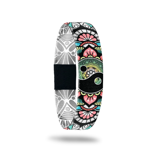 This is a reversible wristband. The outside is muted multicolors of a paisly deign with green, pink, teal and grey. It has a ying-yang in the center of the design. The inside is all grey and white paisley design and says Balance. It can be worn with the design or the words on the outside. 