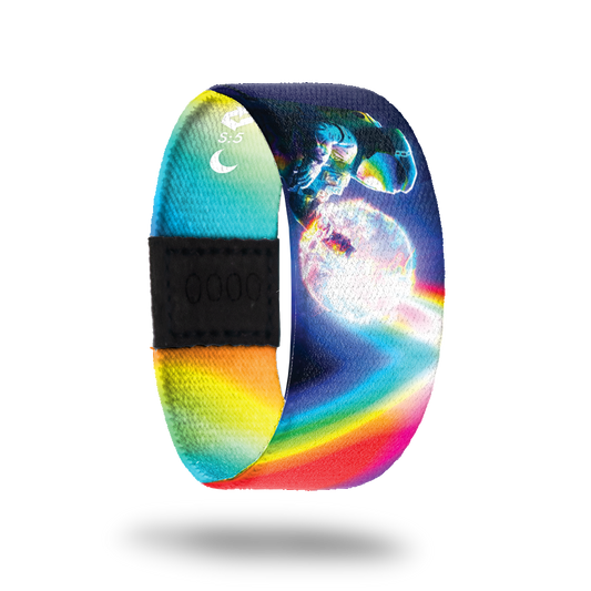 An astronaut floating in space with a glowing sun behind him. Rainbow prism rays all over entire band and reflecting off the astronaut's helmet. Inside is rainbow prisms and says Be A Light. This is a reward item and not purchasable.  