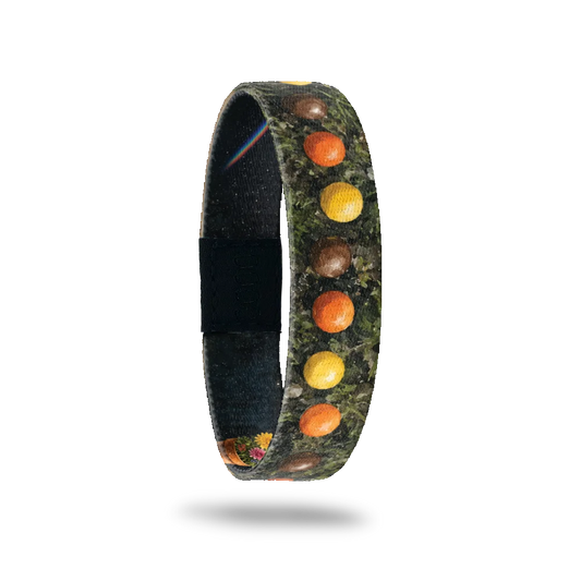 Be Good bracelet showing a row of colourful candy pieces on dark mossy ground