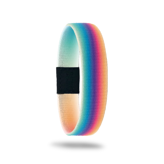 This is a reversible wristband. The design is a gradient rainbow that is blurred so the colors are more muted than primary colors. The inside is yellow and green gradient with the words Believe In Miracles. 