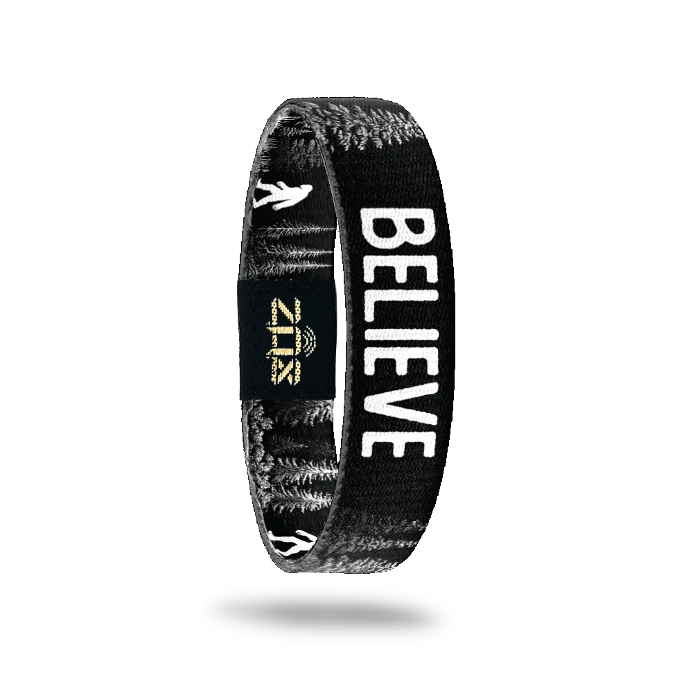 Inside of the Believe bracelet, with the word Believe across the black and white forest print