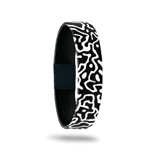 This is a reversible wristband. One one side is a black base with white swirls all over. The inside is the same design and reads Brave Enough To Be Yourself.. It is a single.