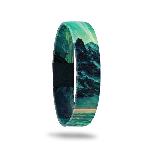 A single wristband with an image of mountains. Colors are teals, blues and greens. Inside reads Dare To Dream. 