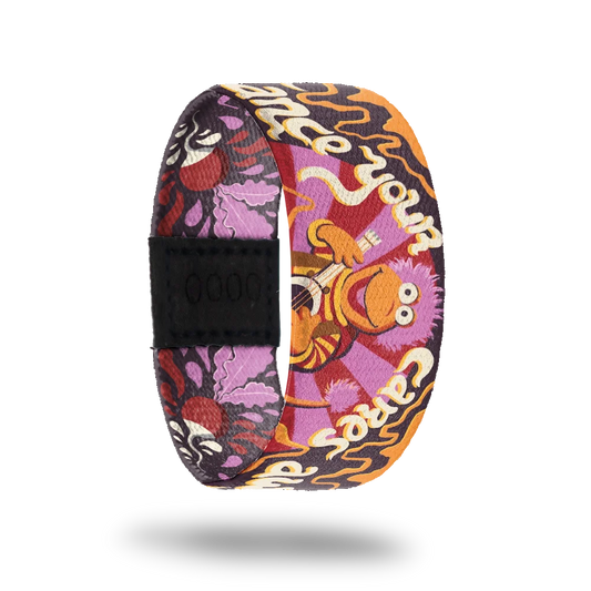 A colorful bracelet featuring Gobo from Fraggle Rock, depicted playing a guitar against a vibrant background with purple, orange, and red swirls. The phrase "Embrace your cares away" appears in playful white font. The design includes floral and abstract elements