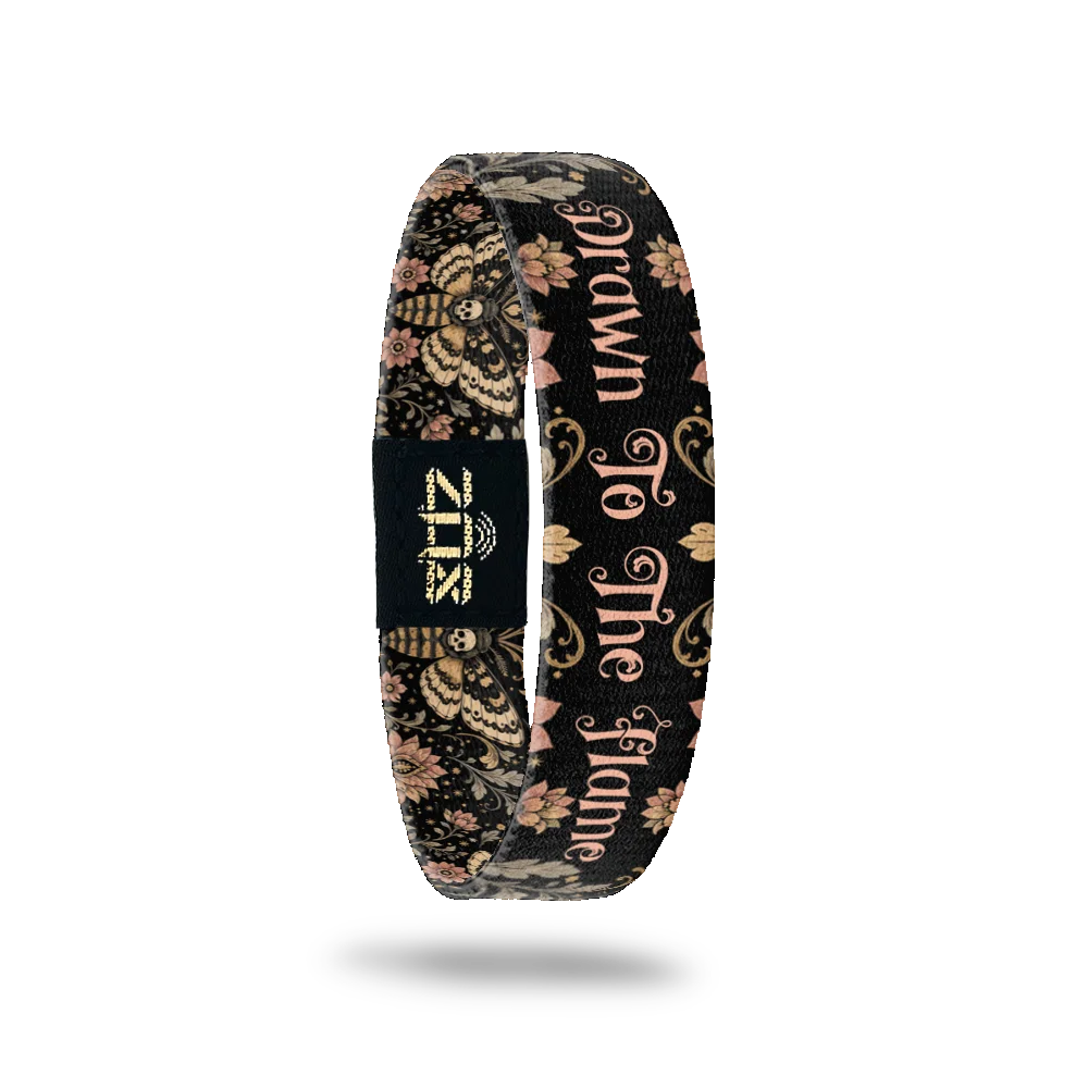 Inside of the Drawn To The Flame bracelet, with the words Drawn To The Flame across the moth and floral print