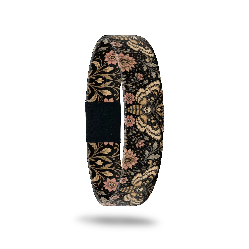 Drawn To The Flame bracelet showing cream and gold moths with skull markings among scrolling leaves and flowers on black
