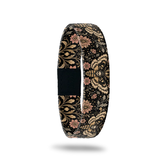 Drawn To The Flame bracelet showing cream and gold moths with skull markings among scrolling leaves and flowers on black