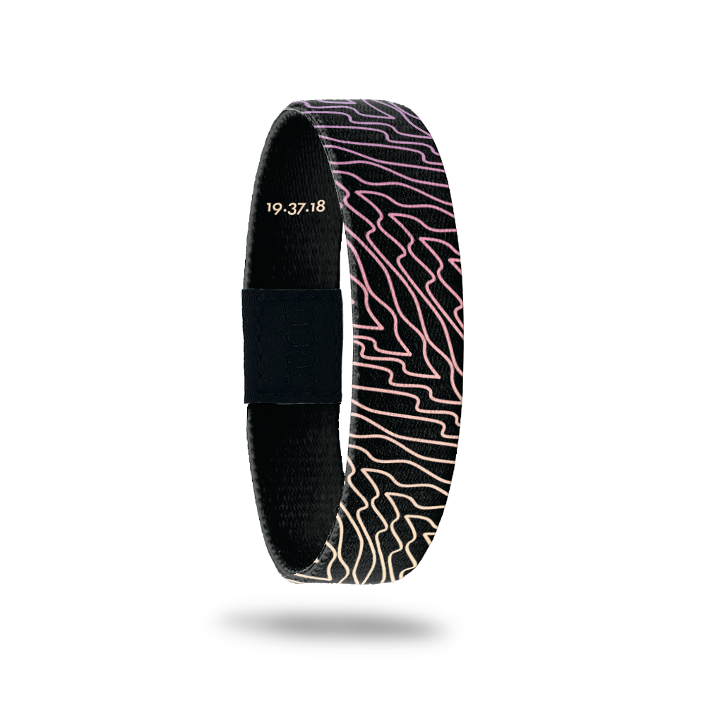 Wristband is black with gradient purple, pink and yellow swirls that are diagonal to the band.  Inside reads Forgiven.