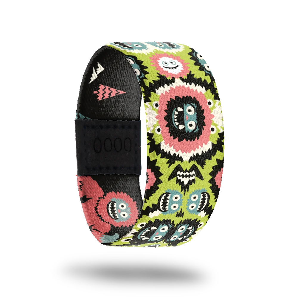 Gone Squatchin' bracelet showing grinning bigfoot faces in pink and teal on lime green with pine trees