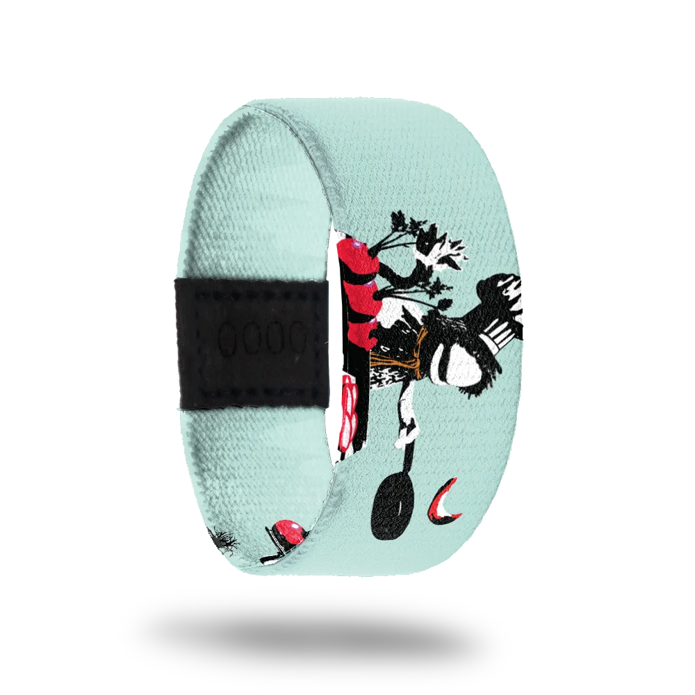 A pastel blue bracelet for #1-100 featuring Boober from Fraggle Rock. Boober is illustrated with his signature hat and scarf, sitting with a frying pan and a bunch of red beets in front of him. The design includes bold black, white, and red accents, adding depth and contrast.