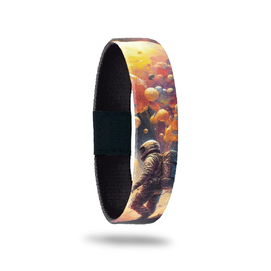 Wristband single is a realistic design of an astronaut walking with bubbles and clouds. The inside is solid black and says It Was All A Dream.