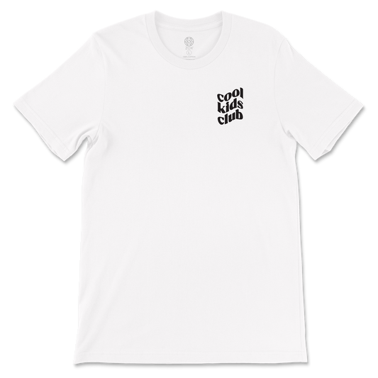 This is a white crew neck tshirt. The left chest reads Cool Kids Club in a wavy font and the back is a large smiley face in yellow. Around the face it reads It's Still Cool To Be Kind. 