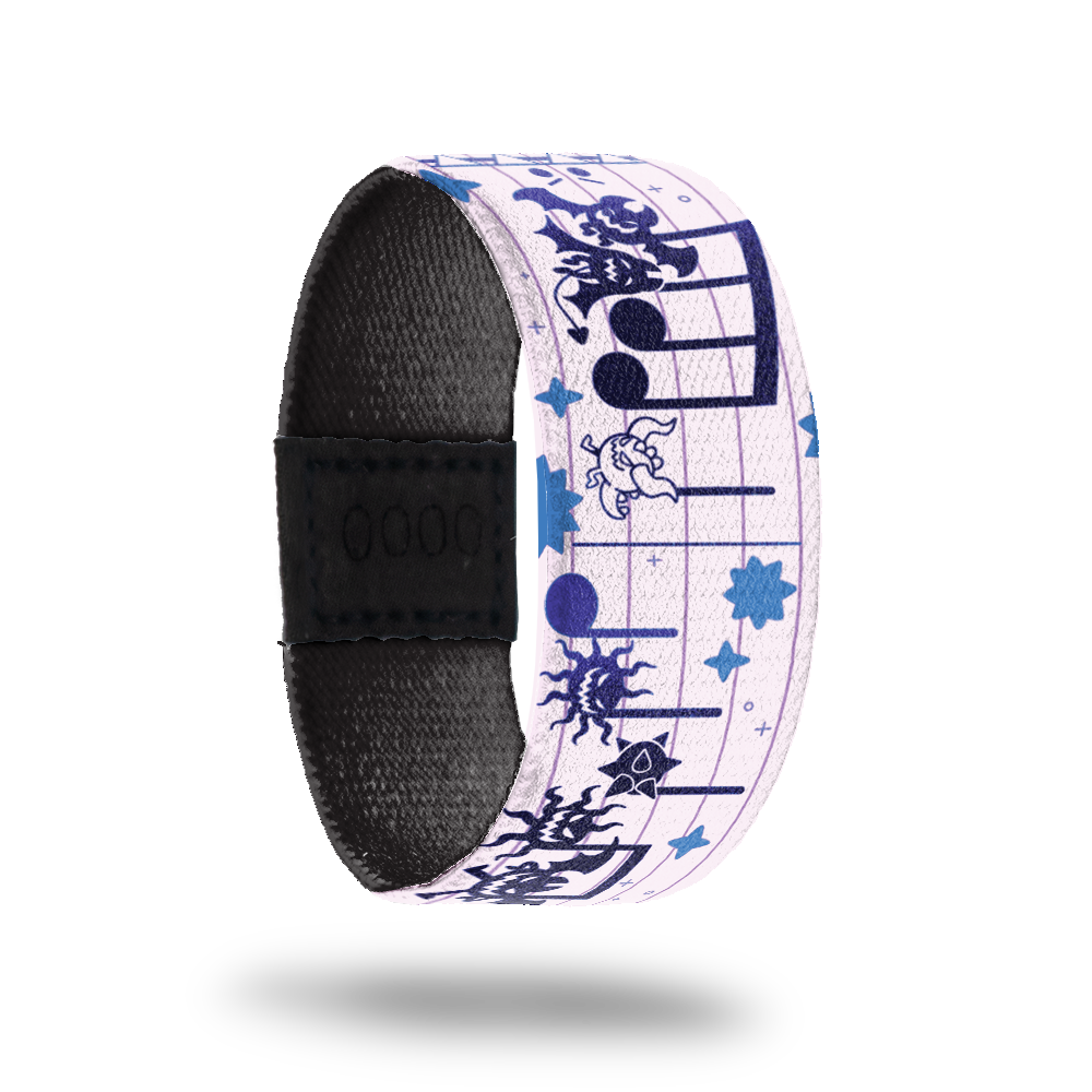 White strap with monsters that represent the music notes on a sheet of music in purple and blue. Inside is solid black. Comes with a matching pin of a monster with multiple mouths singing from a sheet of music. 