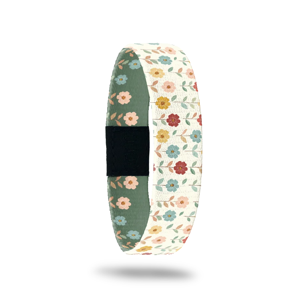 Love Grows Here bracelet showing small hand drawn folk flowers in red, blue and gold on cream