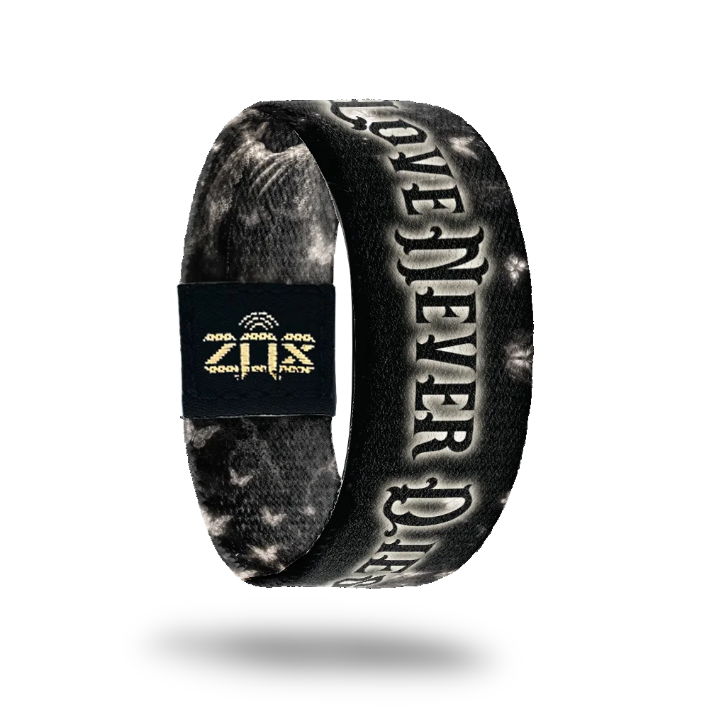 Inside of the Love Never Dies bracelet, with the words Love Never Dies across the sugar skull print