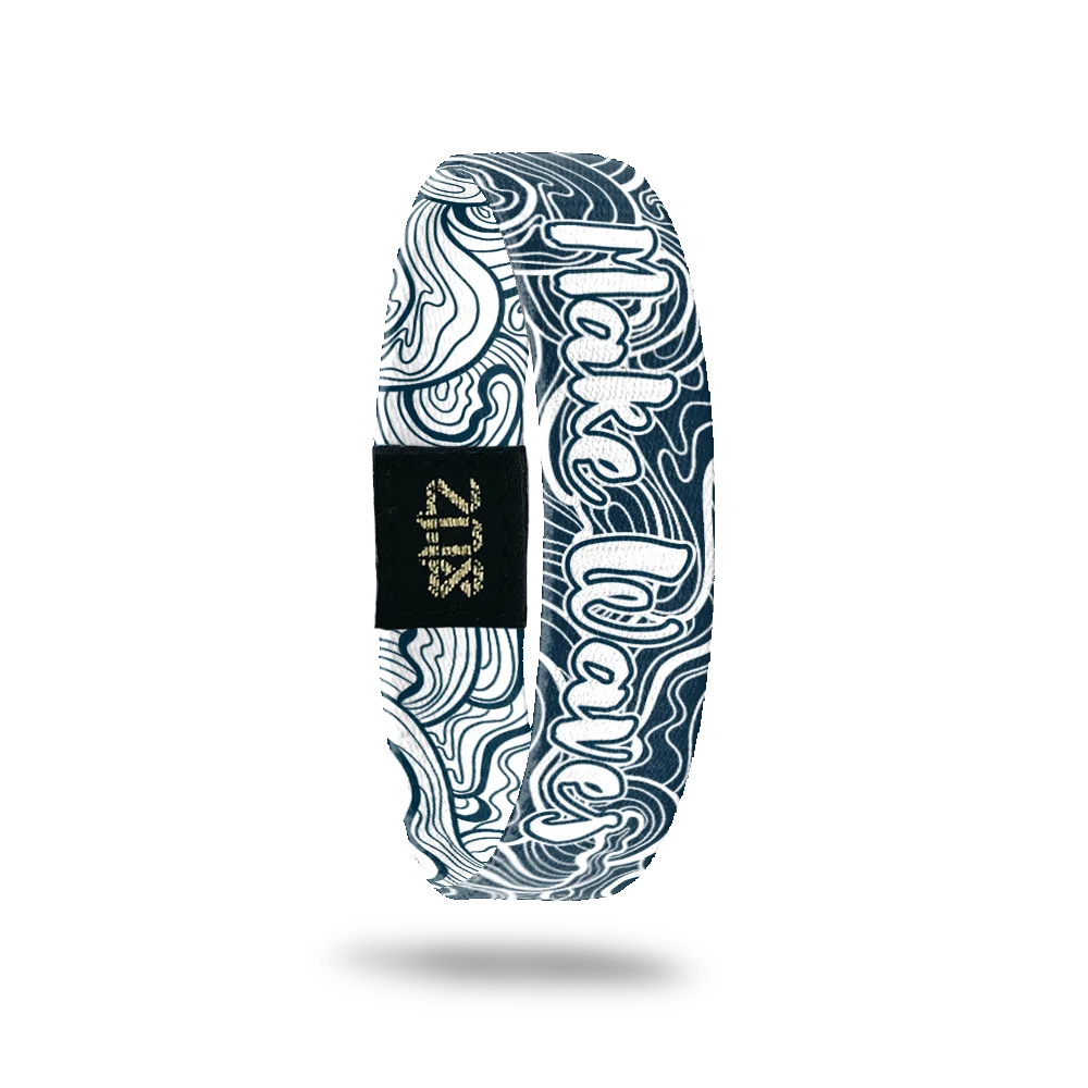 Dark blue/teal with white abstract waves and says Make Waves.