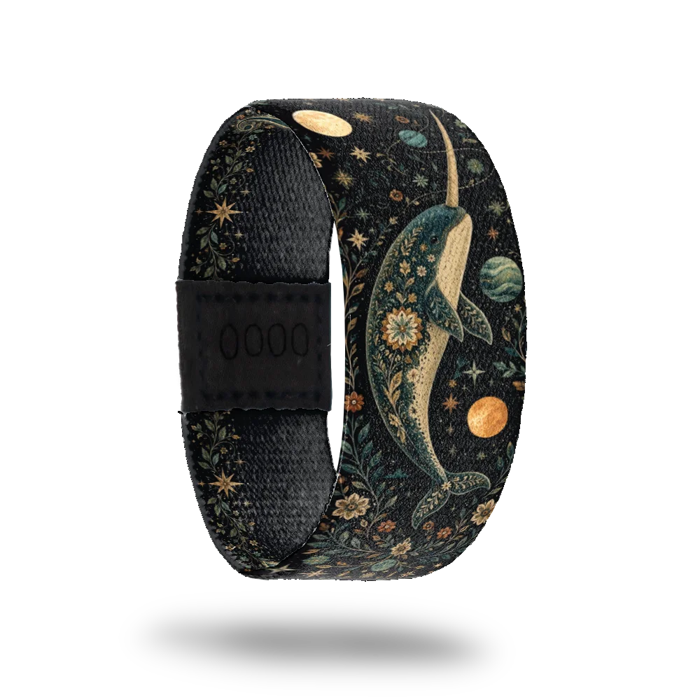 Part Unicorn bracelet showing a narwhal in gold and deep blue among stars, planets and leafwork