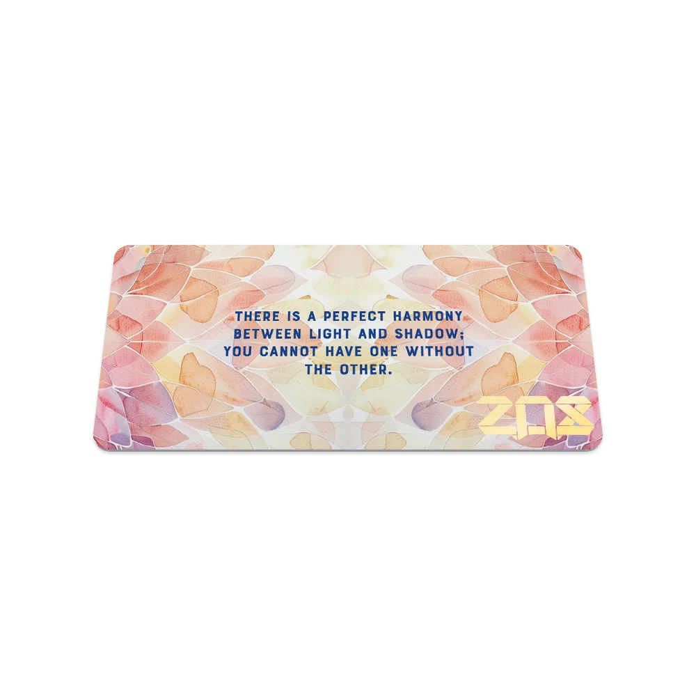 Product photo of the back of the collector’s card for Perfectly Balanced, featuring a pastel watercolor petals in shades of pink, orange, and beige. Blue text in the center reads, "There is a perfect harmony between light and shadow; you cannot have one without the other." The gold "ZOX" logo is in the lower right corner.