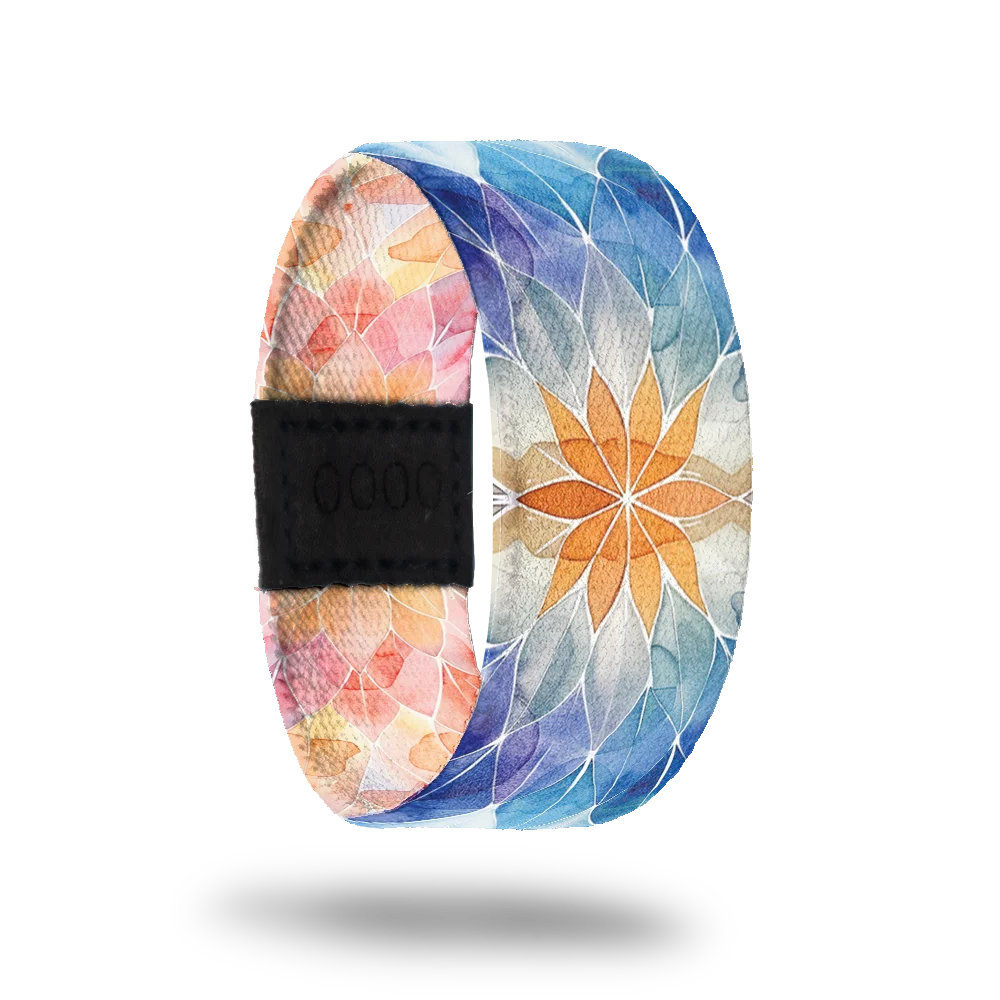 Product photo of the outside of the Perfectly Balanced which features a soft, watercolor-style mandala design. The pattern transitions from warm tones of orange and pink on one side to cool shades of blue on the other.