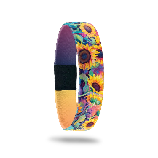 Wristband single with very bright and neon sunflowers with vines of blue, purple, pink. The inside is purple to yellow gradient and reads Radiate Positivity. 