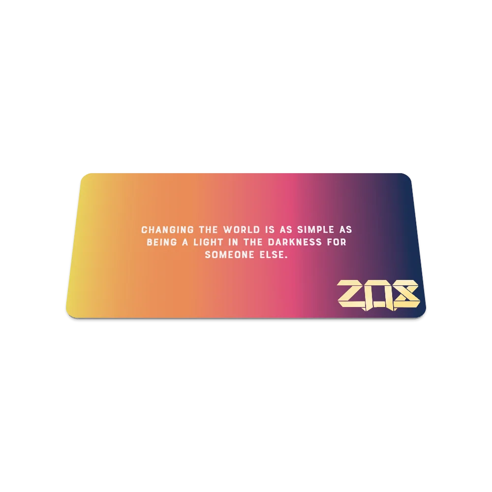 Product photo of the back of the collector’s card for Radiate Positivity. The back design has a smooth gradient that transitions from yellow to deep pink, with a motivational quote in white text: "Changing the world is as simple as being a light in the darkness for someone else." The ZOX logo is displayed in gold in the bottom right corner.