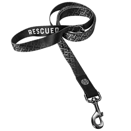 Dog leash with a black and white design of dog bones all over. The hoop handle reads Rescued. Comes with a metalpull-down hook. 