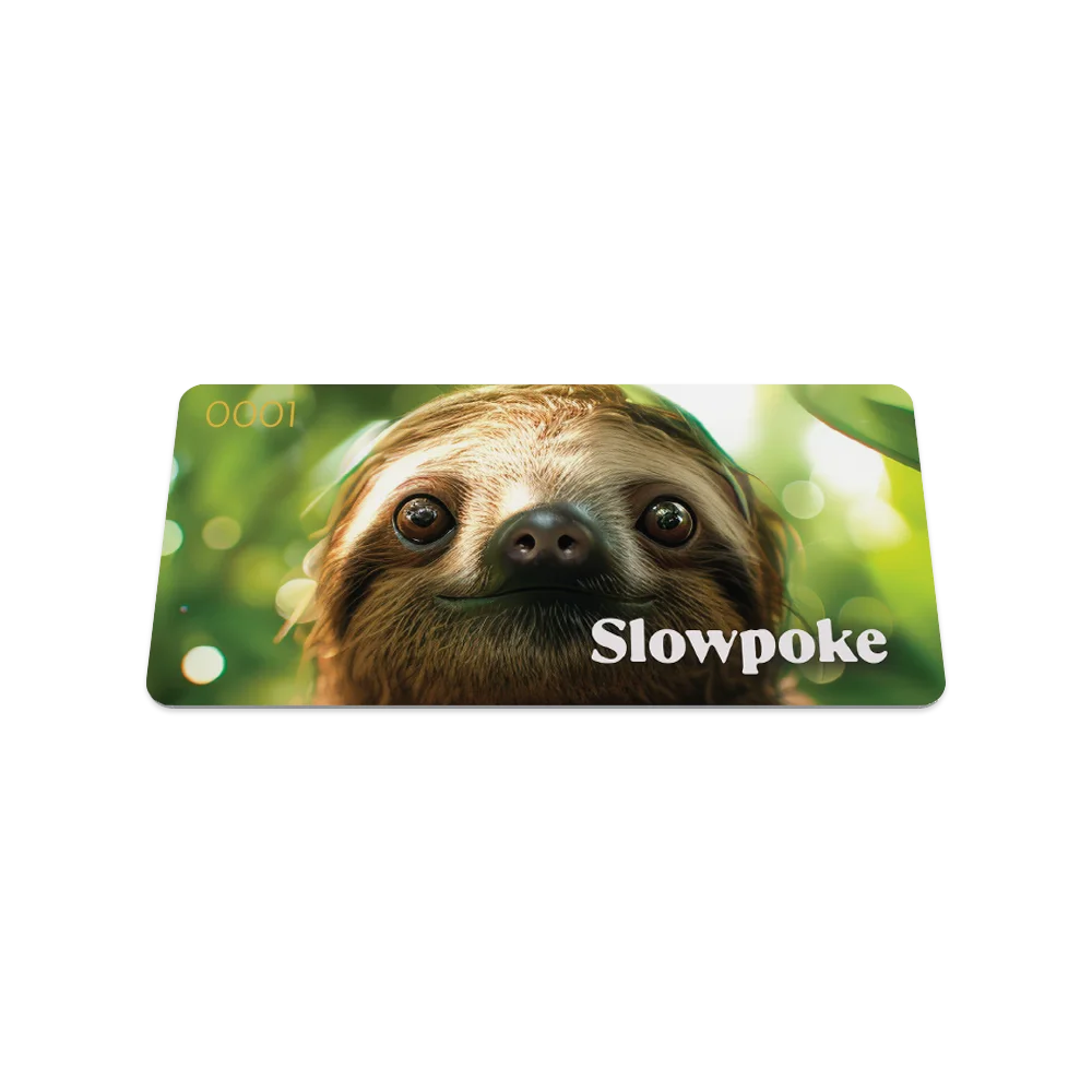 A card featuring a close-up image of a sloth's face with large, expressive eyes, set against a lush, green forest background with soft sunlight. The word "Slowpoke" is written in white, bold letters on the right side, with a small serial number "0001" in the upper left corner.