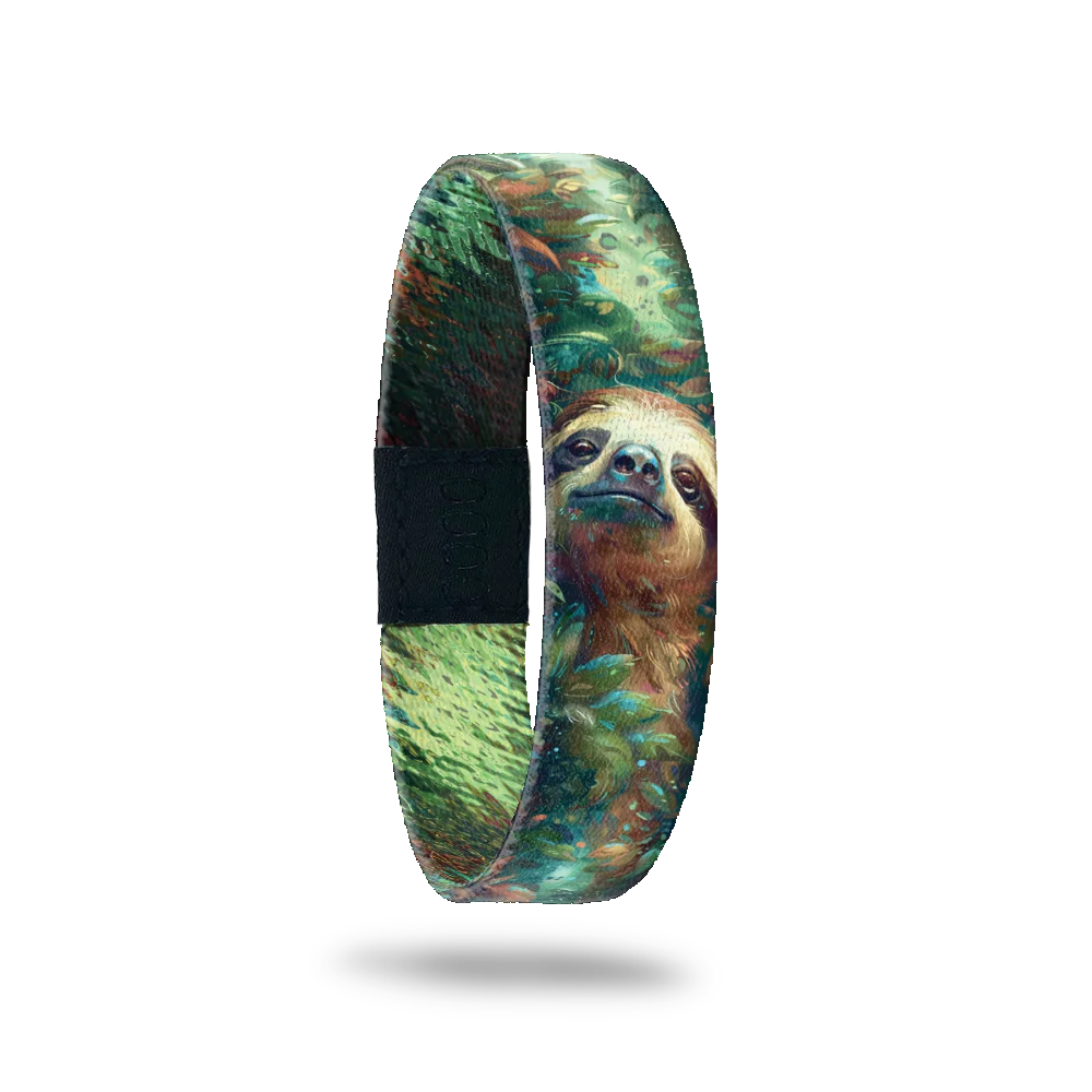 A bracelet featuring a detailed illustration of a content sloth surrounded by lush, green foliage. The design includes shades of green, brown, and blue, creating a serene, natural atmosphere. A black rectangular patch with etched serial numbers is visible on one side of the strap.