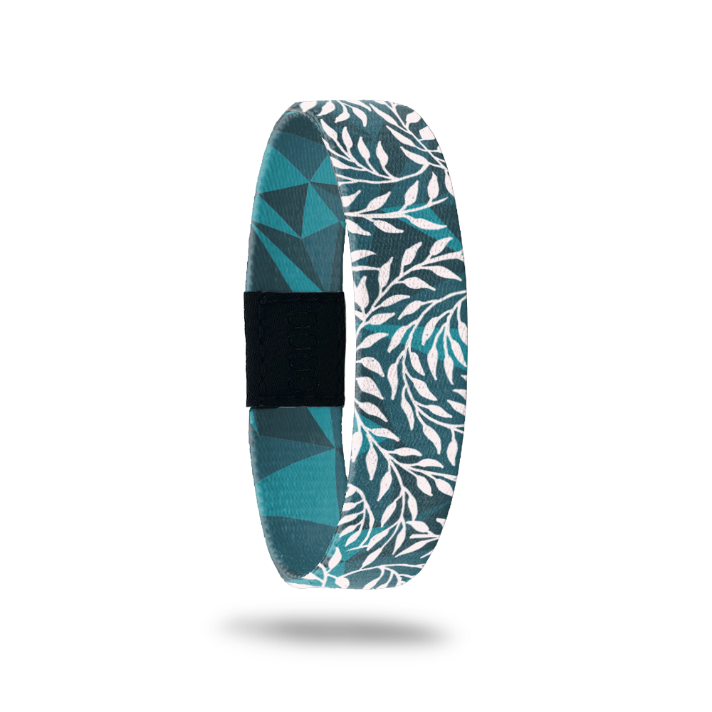 Wristband single that is teal and turquoise geometric design. It has all white vines on top that wrap around the band. The inside is the same design without the vines and says Hope Over Fear. 