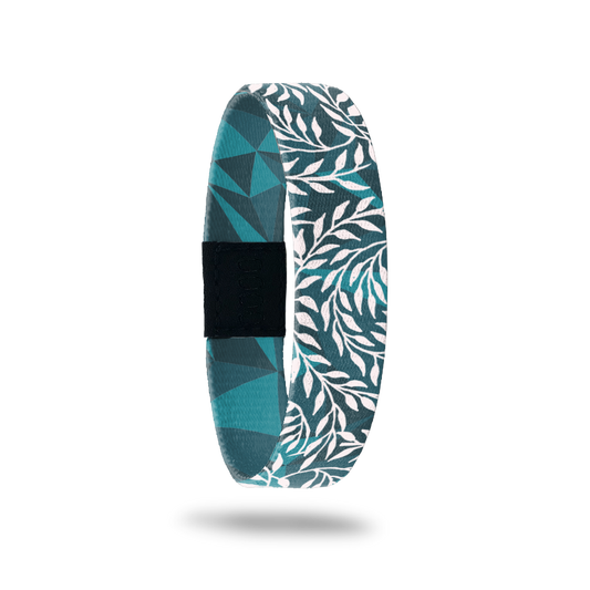 Wristband single that is teal and turquoise geometric design. It has all white vines on top that wrap around the band. The inside is the same design without the vines and says Hope Over Fear. 