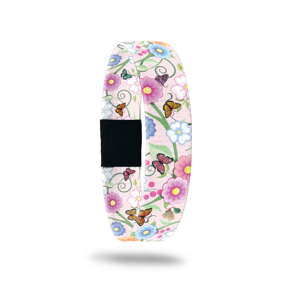 Wristband single with a very light pink base. The design is mulitcolored and has glowers and butterflies all over. The inside is the same and says I Love You Mom. 