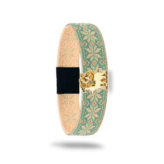 Wristband single with beige and light green vintage sweater design with specs of orange. The design is snowflakes and dots. Comes with a matching charm of a reindeer. The inside reads Joy To The World. 