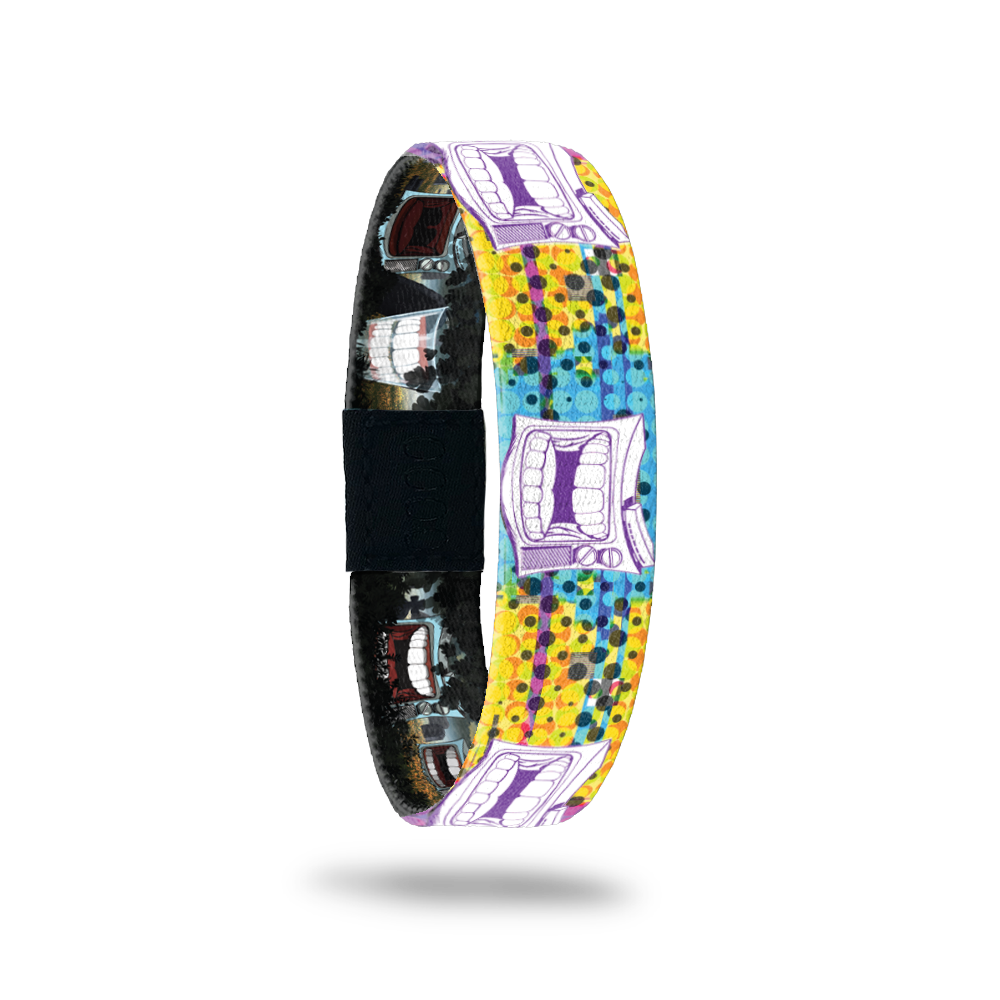 Bracelet is multicolored with yellow, teal and range dots/design. Has an old-school TV with chatter teeth on the design. Comes with a pin of a chatter teeth set. 