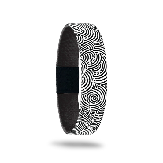 Wristband single with a black and white circular maze design all over. The inside is the same and in teal reads One Day At A Time.