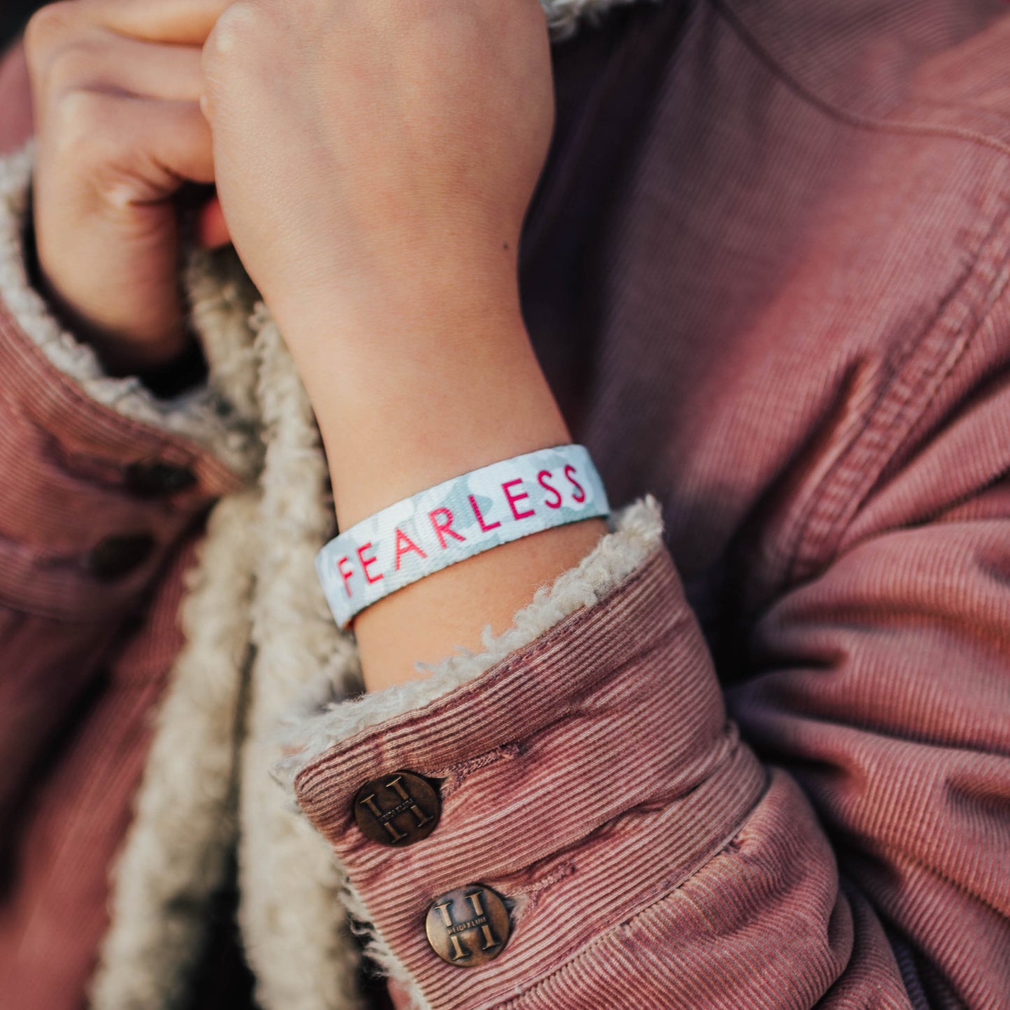 Lifestyle image close up of Fearless on model's wrist