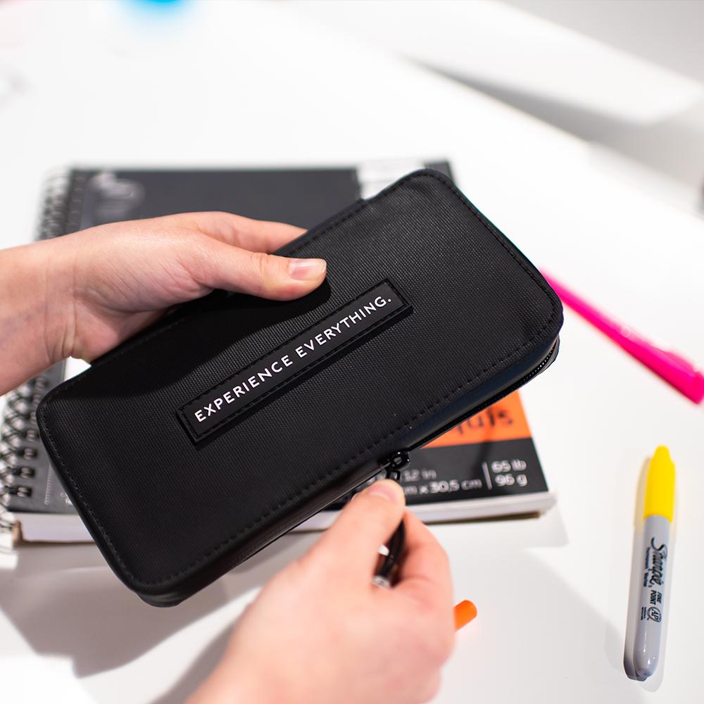 Lifestyle photo of the artist capsule being opened with some markers and a notebook on the table