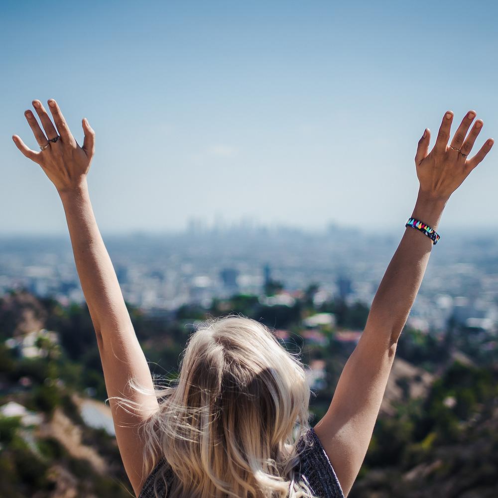 Lifestyle image of someone raising both their hands to the sky with a Bold Imperial on their wrist